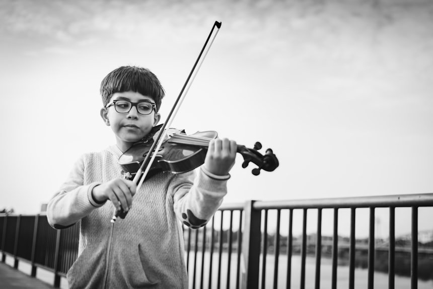 Boy playing violin &mdash; focused young student with bow on strings